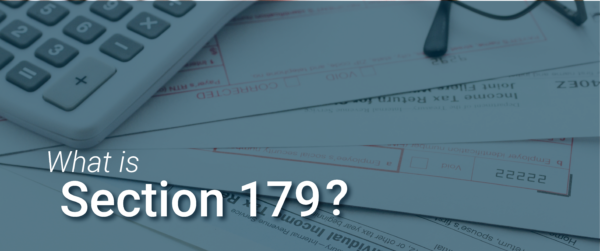 A close-up of tax forms and a calculator, with the text 'What is Section 179?' highlighting the concept of tax deductions for equipment purchases.